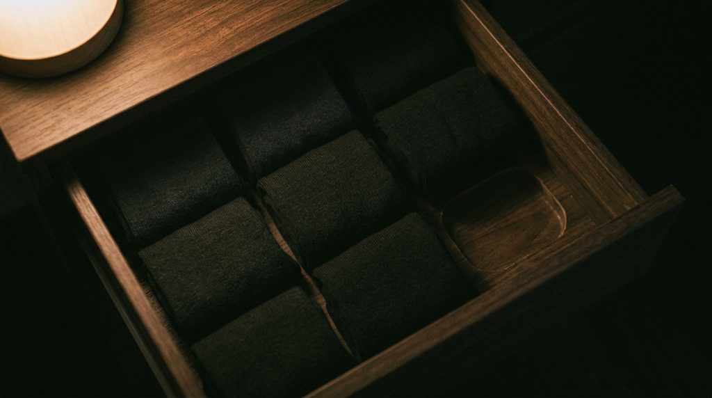 引き出しの中に同じ種類でそろえて並べられた黒い靴下