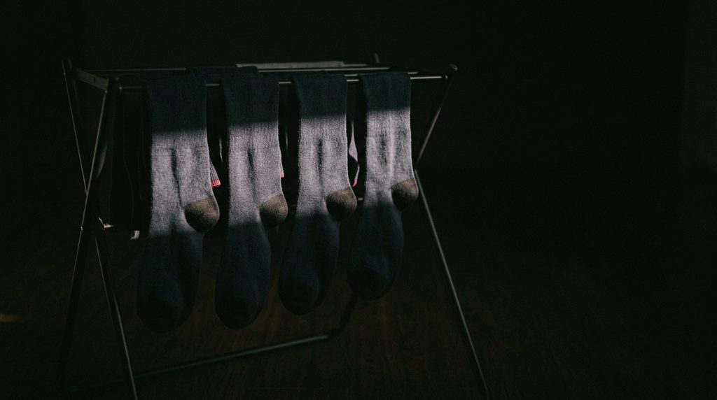 暗い室内で干された数足の靴下と、そこに差し込むわずかな朝の光